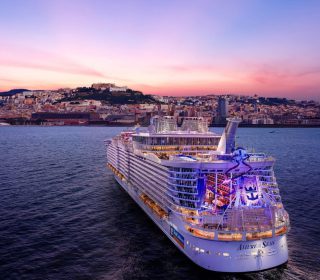 Panoramic view from sea of Naples coastline, Italy. Big cruise ships are in port, cityscape in sunny weather with blue sky and white clouds.