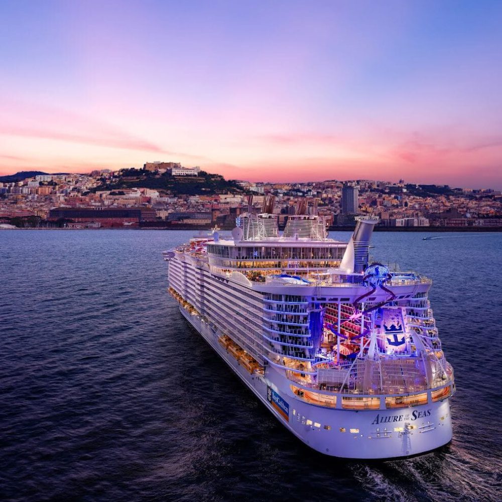 Panoramic view from sea of Naples coastline, Italy. Big cruise ships are in port, cityscape in sunny weather with blue sky and white clouds.